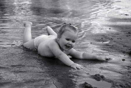 The cheerful little girl floating in small river