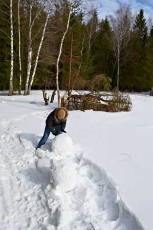 attractive girl makes a snowman