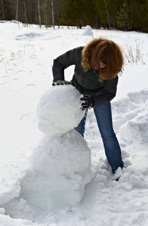 attractive girl makes a snowmanの写真素材