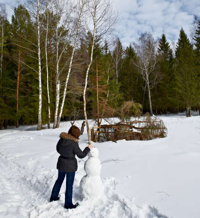 attractive girl makes a snowmanの写真素材