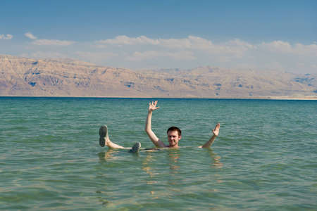 Caucasian man floating in the waters of the Dead Sea in Israelの写真素材