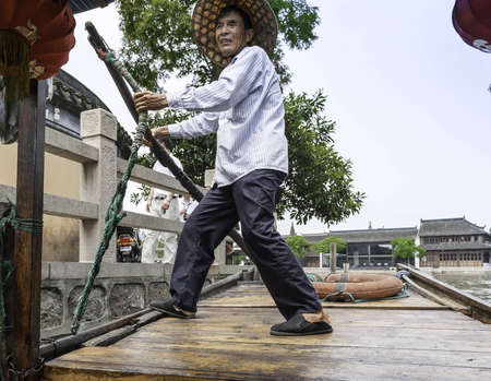 ZHOUZHUANG-AUGUST 19: Chinese gondolier sailing on a boat in the village on the water, on August...