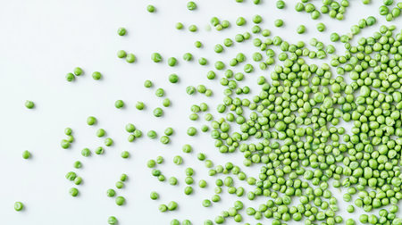 Fresh green peas scattered across a white background create a vibrant and visually appealing image perfect for culinary applications and healthy eating themes.の素材