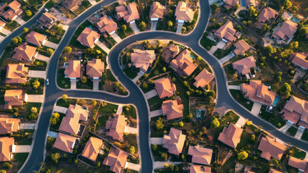 Stunning aerial view showcasing a residential neighborhood with winding streets and charming homes surrounded by greenery, perfect for urban living and community life.の素材