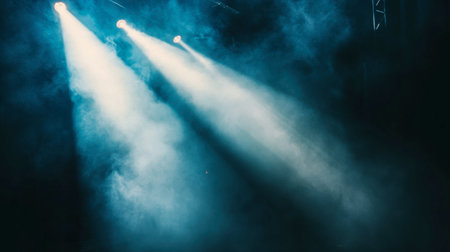 Striking blue light beams cut through swirling smoke on a dark stage, creating an atmospheric and immersive experience ideal for concerts or performances.の素材