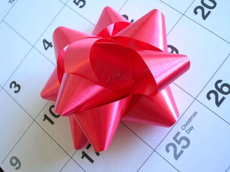 Christmas Day on a calendar with a red bow.の写真素材