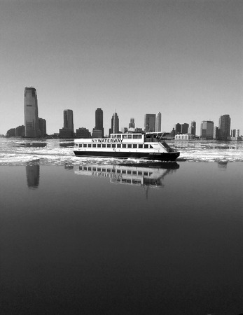 New York City, USA - February 28, 2015 - New York commuter ferry crossing the icy Hudson River with the Jersey City skyline in the background.のeditorial素材