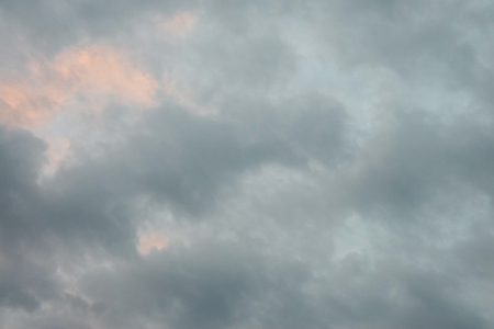 Sun rays and dark clouds at sunsetの写真素材