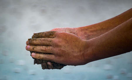 Hands playing in the sand.の写真素材