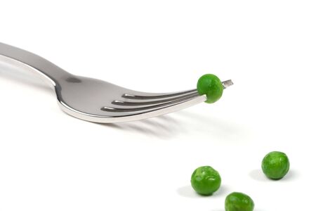 Fork and three peas symbolizing a radical dietの写真素材