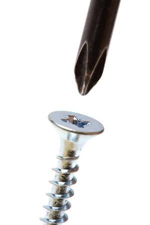 Screw and screwdriver macro shot over whiteの写真素材