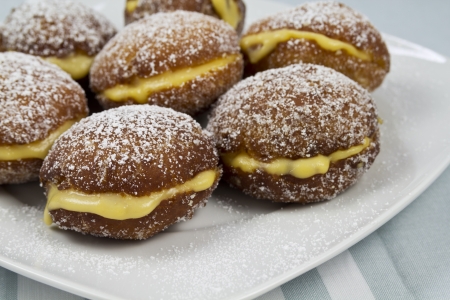 Berliners with cream on a white plateの写真素材