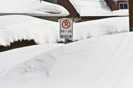 MARCH 9 2008: Snow drifts as high as the streetside parking signs after a heavy snow storm in Ottawa Ontario Canada.の写真素材