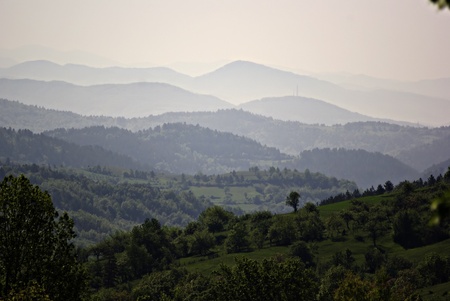 Forested mountain landscape with the peaks that disappear into the mist in the distance.の写真素材