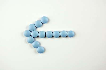Pills, medicals, drugs, tablets in blue, arrow shaped, unpacked.の写真素材