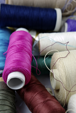 Sewing cotton in different colors, packed and unpacked, in plastic box.