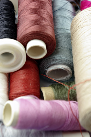 Sewing cotton in different colors, packed and unpacked, in plastic box.