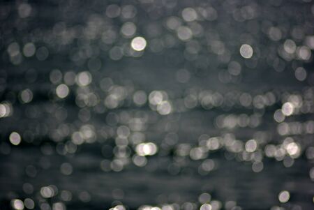 Sea surface with out of focus sun reflections and waves at sunny summer afternoon.の写真素材