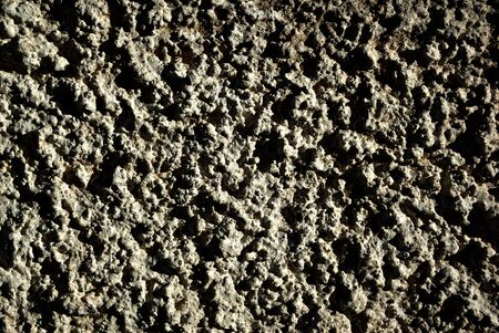 Seamless stucco wall texture at sunny summer daylight with shadows.