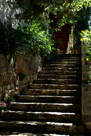 Mediterranean garden courtyard with natural stone wall and staircase.の写真素材