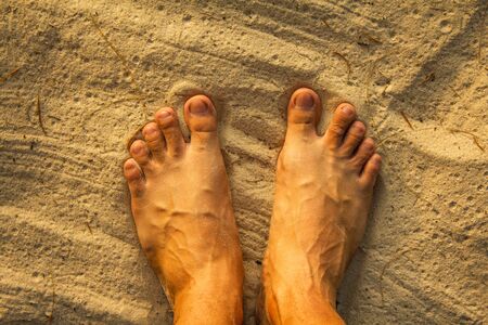 some day in summer holiday, man feet on the beach sand