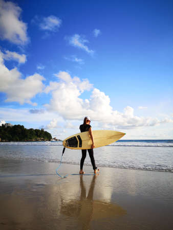 somebody standing on the beach and soft wave crashing on their lags