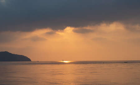 Amazing sunrise over the seashore, Beautiful cloudy sky and a golden beam light emanating from heaven, Morning seaの写真素材