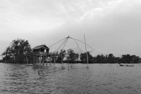 The silhouette Shrimp fishing trap in Thailand, traditional thai lifestyle of fishermen in the evening, local fishing gear of Thailand, normal name is yor.の写真素材