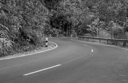 black and white the country asphalt road through the forest go to somewhere in the mountain.