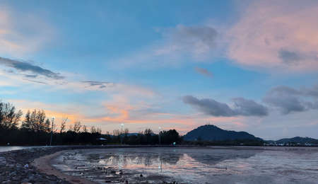 twilight time sunset at park beach with low tide, twilight sky reflex on low tide beach. Sapanhin Phuket Thailand May 15,2021.の写真素材