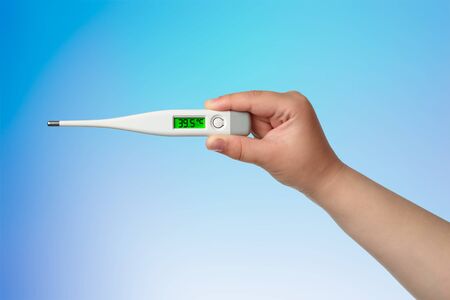 Chilld hand with thermometer with high temperature 39.5 on the blue backgroundの写真素材