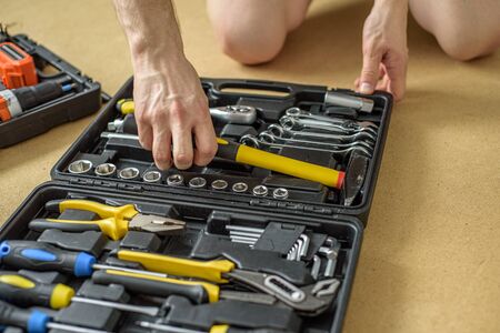 A man took tool from a case for work. Close up