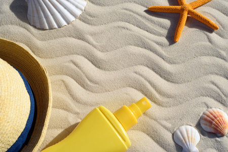 Seashells, starfish, sun hat and sunscreen on the sand. The concept of protecting the skin and body from the harmful effects of ultraviolet radiation. Copyspaceの写真素材