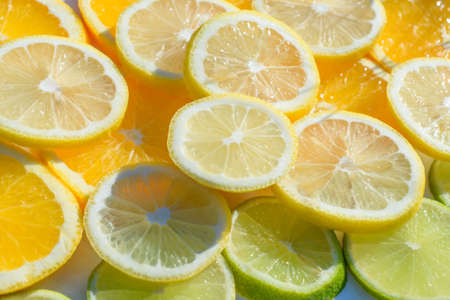 Green and orange slicaes of the lime and orange. Backgroundの写真素材