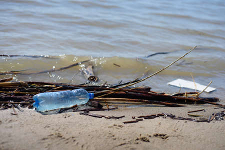 Seashore contaminated with plastic and other debris. Global problems of environmental pollutionの写真素材