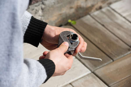 Male hands install a water tap at outdoor. Do it yourselfの写真素材
