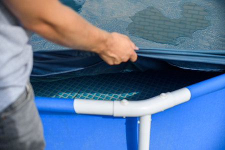 A man pulls up an cover over a home swimming pool. Debris protectionの写真素材