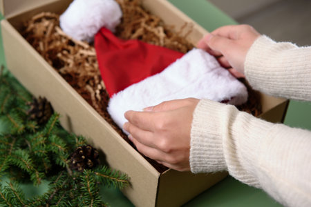 Women's hands take out a santa claus hat from the box. Preparations for the new year and Christmas. Winter holidays timeの写真素材