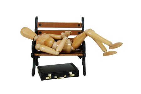 Leather briefcase used to carry items to the office, wooden park bench with metal scroll sides, wooden model representing a personの写真素材