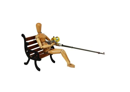 Fishing pole with rod and reel used to catch fish, wooden park bench with metal scroll sidesの写真素材