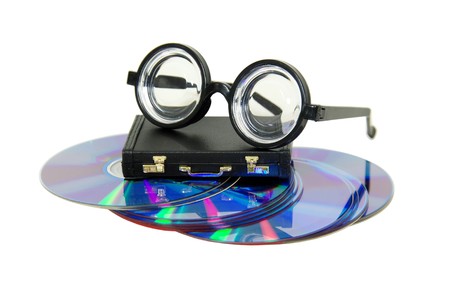 Thick lenses on black frames, leather briefcase used to carry items to the office, purple dvds with red interiorsの写真素材