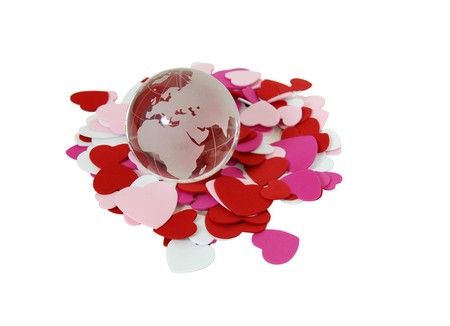 Crystal globe with navigational lines surrounded by heartsの写真素材