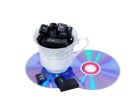 A couple of purple dvds with red interiors, and a teacup full of keyboard letters-Path orig sizeの写真素材