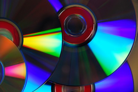 A couple of purple dvds with red interiors splashing and rainbow of color in the light