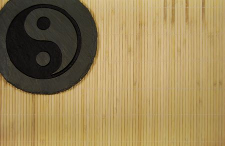 Ying yang symbol of unity and peace which is prevalent in many Asian works on a grass matの写真素材