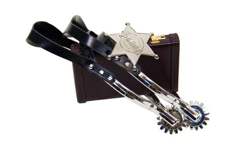 Cowboy spurs and sheriff star in silver and leather on a briefcase to tame a wild business