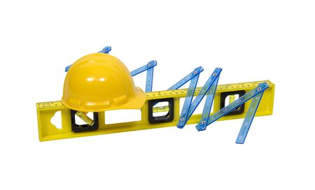 Yellow hard hat worn for protection when working on construction sites with a folding ruler and a...