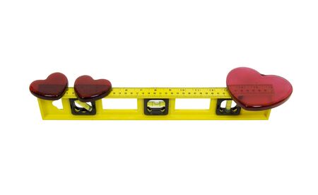 Love on the level shown by a yellow level with bubbles and measuring indicators balancing out a set of hearts - includedの写真素材