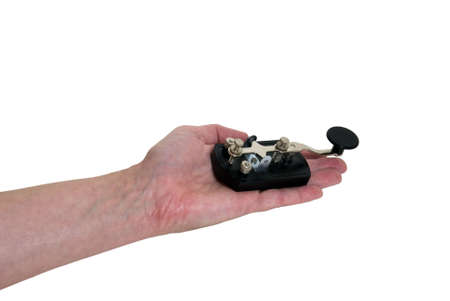 Offering communication shown by holding out an antique telegraph key used as a communication device for Morse Codeの写真素材