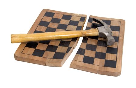 Game over shown by hammer with a wooden handle on a broken wooden chess boardの写真素材